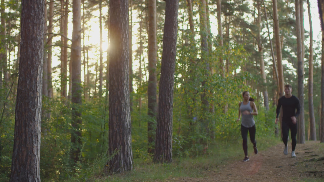 A sporty couple jogging in the forest